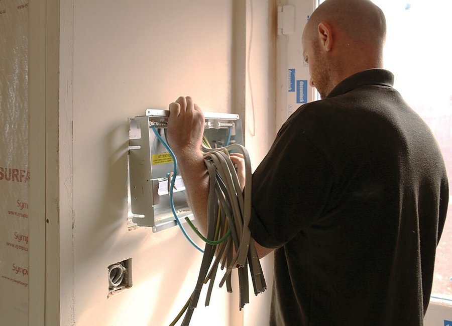 Electrician wiring a new consumer unit into a property