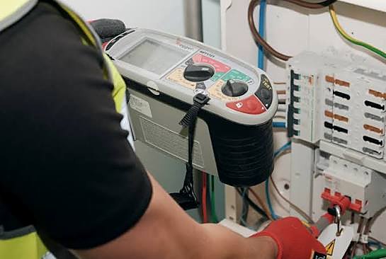 Electrician testing a consumer unit with a Megger installation tester